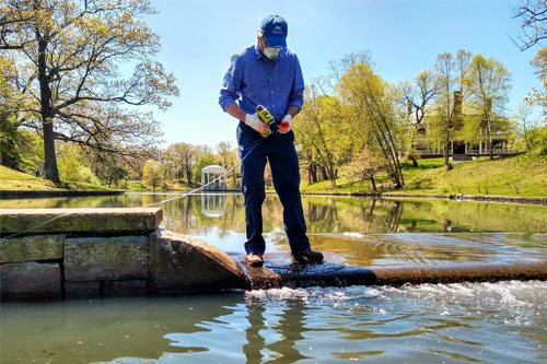 photo of a person monitoring a dam - link opens to storm water management page