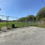 photo of a fence and gate that surrounds a soccer field