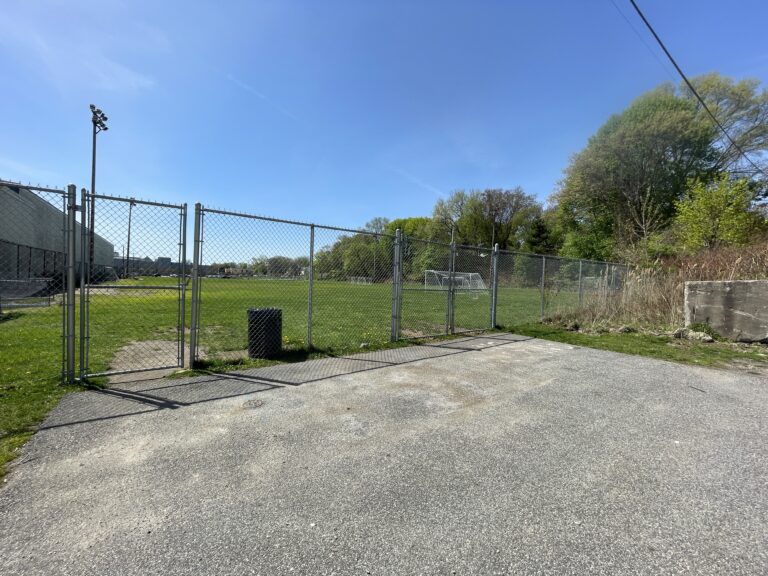 photo of a fence and gate that surrounds a soccer field