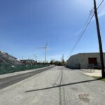 photo of a street with wind turbines in the background