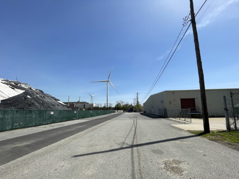 photo of a street with wind turbines in the background