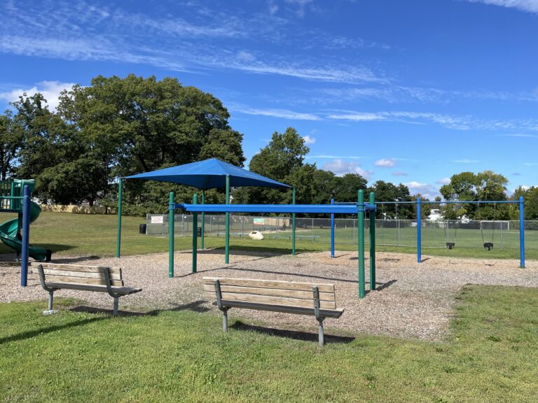 Hopkins Park playground benches from the parking lot