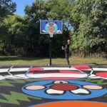 photo of a person playing backetball on a colorful basketball court