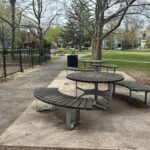 photo showing picnic tables in a providence park and a child playing in the background
