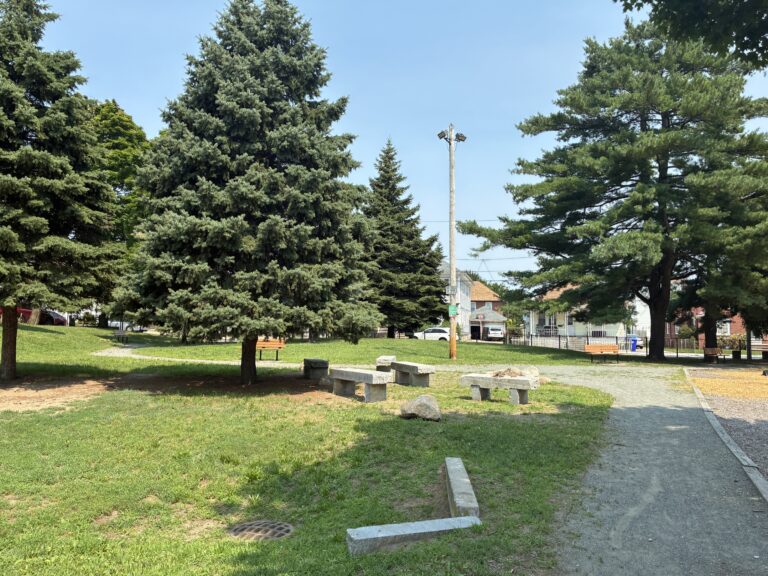 photo showing walking path, trees, grass areas, and seating