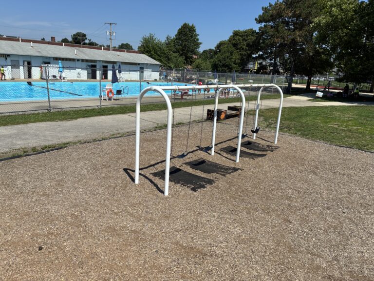 photo showing swings with a pool in the background