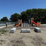 photo showing playground structures and apool in the background