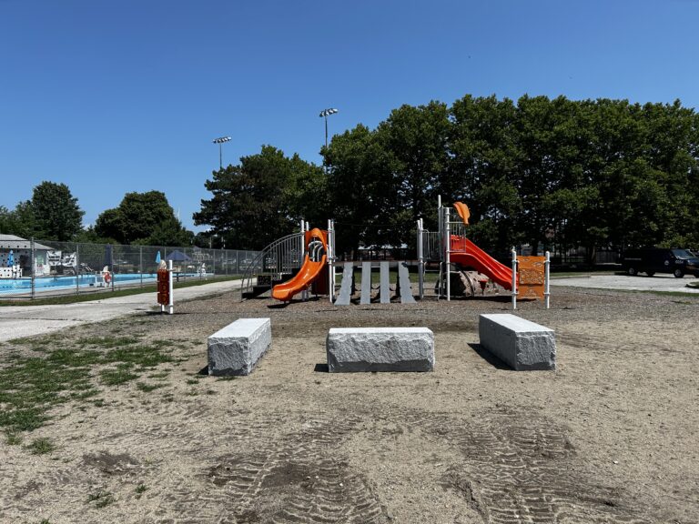 photo showing playground structures and apool in the background