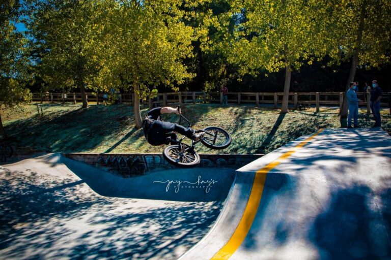 A photo of a BMX rider doing a trick on a ramp at the skate park