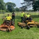 Parks crew at Hopkins Park with two on ride-on mowers