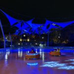photo showing people using bumper ice cars at the providence skating rink at night