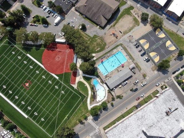 photo showing a birds eye view of a baseball field, football field, swimming pool, basketball courts, and splashpad