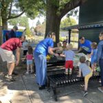 Photo of children and adults using the picnic tables at a Providence Park