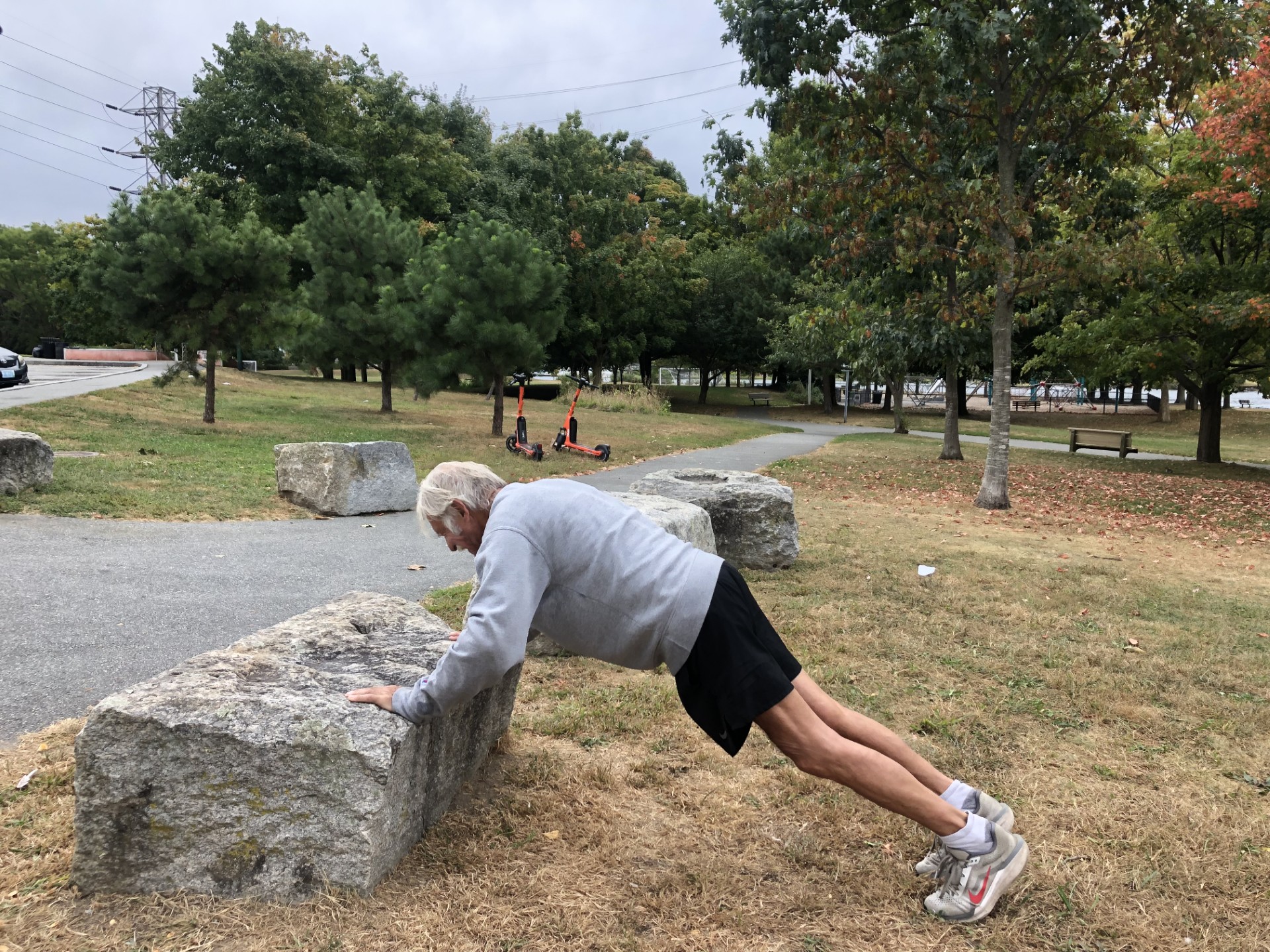 Photo of a person doing a push up on a large stone boulder