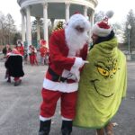 Photo showing Santa pointing at someone with a blanket that has the Grinch on it