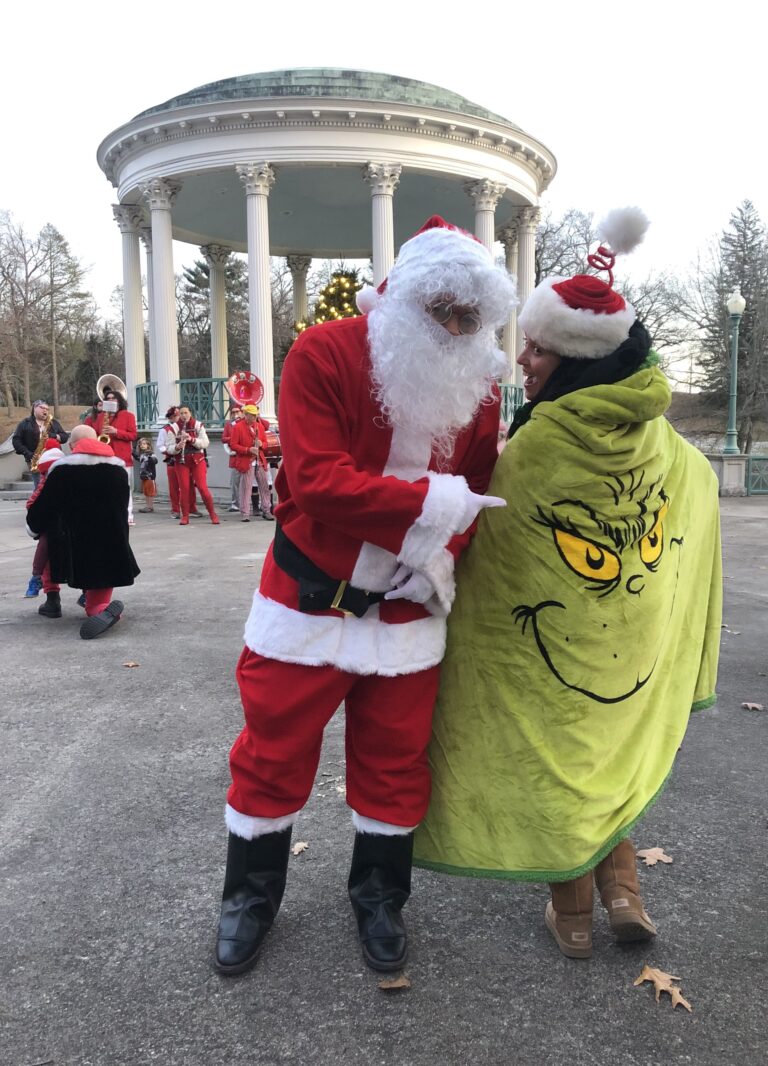 Photo showing Santa pointing at someone with a blanket that has the Grinch on it