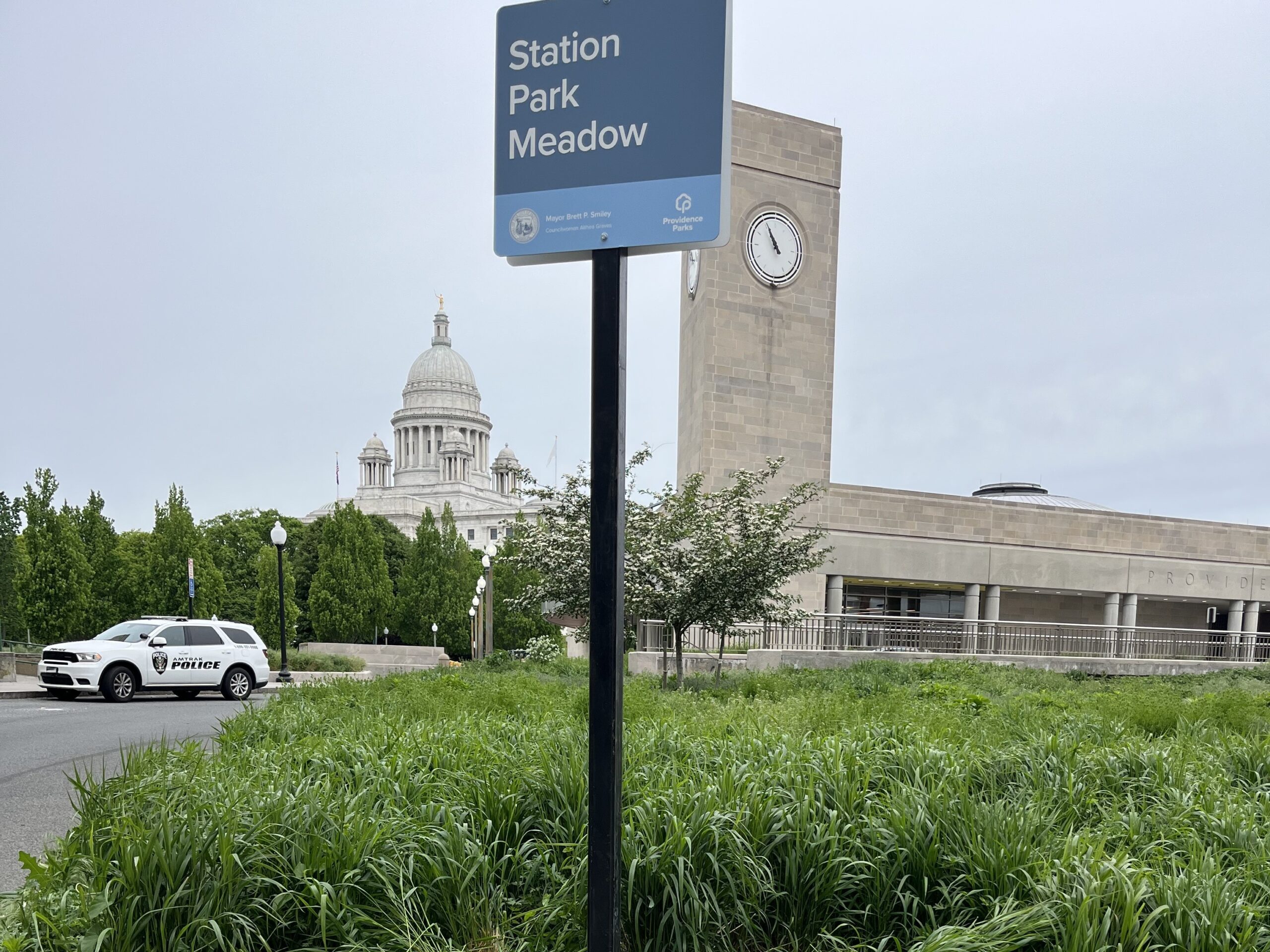 photo showing a sign for station park meadow with the meadow and train station in the background