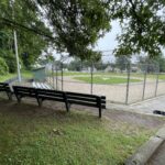 Neutaconkanut little league field viewed from elevated benches behind home plate backstop
