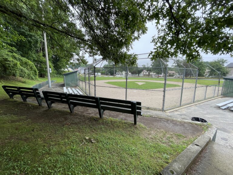 Neutaconkanut little league field viewed from elevated benches behind home plate backstop