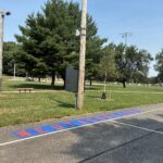 Neutaconkanut basketball court with painted stencil of park name