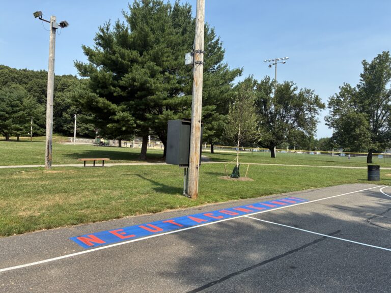 Neutaconkanut basketball court with painted stencil of park name