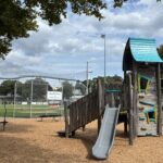 Fargnoli Park playground and ballfield with sign on backstop