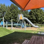 Neutaconkanut playground with accessible carousel viewed from picnic table