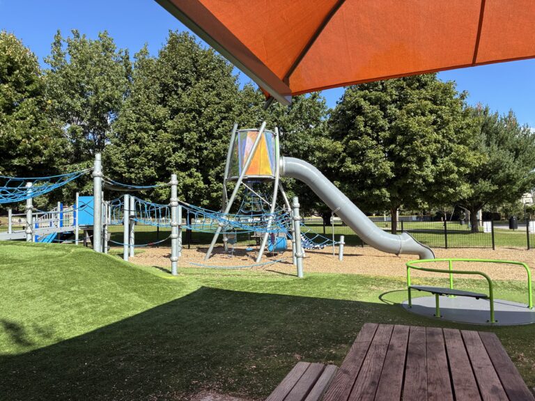 Neutaconkanut playground with accessible carousel viewed from picnic table
