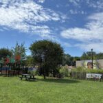 Father Lennon Park from Camden Ave looking at a picnic area and community garden with mural on the Rogers Rec Center