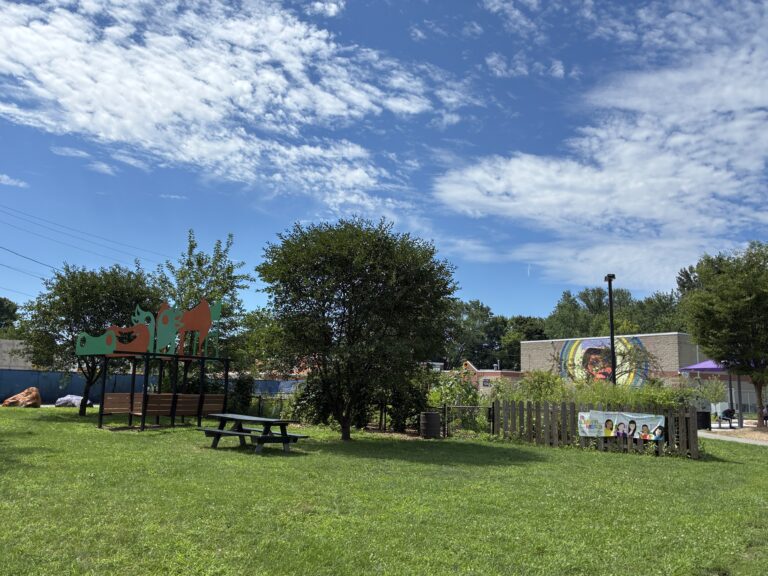 Father Lennon Park from Camden Ave looking at a picnic area and community garden with mural on the Rogers Rec Center
