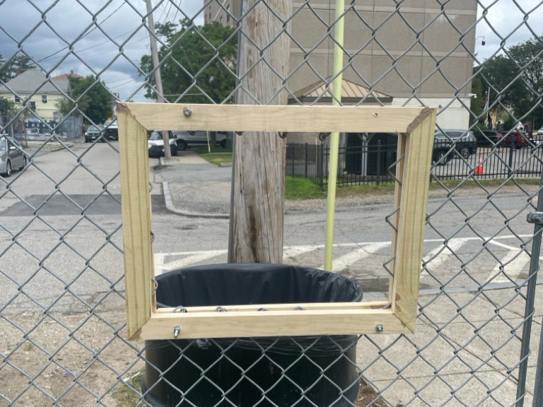 Franciscan Park innovative chute in fence along Ridge St to deposit bagged dog waste