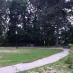 Franciscan Park interior walking path with benches and lamp posts