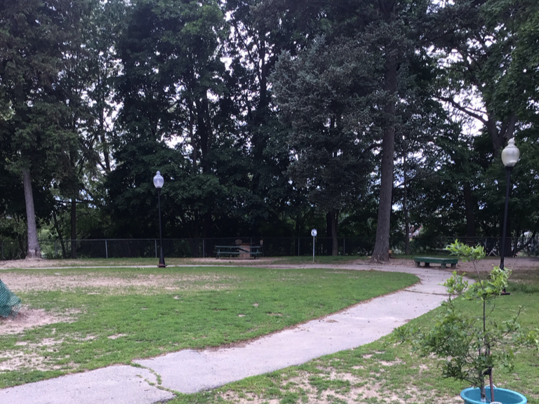 Franciscan Park interior walking path with benches and lamp posts