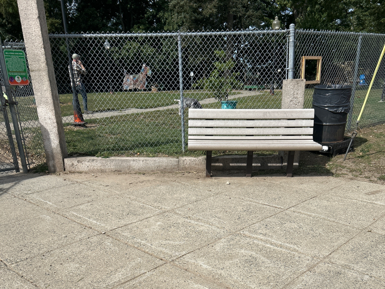 Franciscan Park features two benches on the outside of the park fence on Ridge St