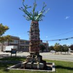 “The Storytelling AncesTree” sculptural installation at Columbus Square facing Reservoir Triangle sign