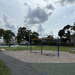 Harriet & Sayles Park paved walking path connects park amenities and entrances on Oxford, Harriet, and Sayles Streets, here running alongside a swing set for ages 5-12