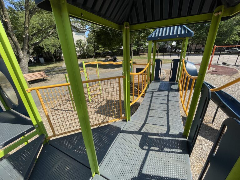 Hassett Park view from inside play structure with roof across bridge to curved slide