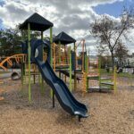 Hassett Park play structure for ages 2-12 features a bumpy slide and various climbers