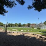 Iola French Park playground equipment for ages 5-12 includes an obstacle course. A grass berm separates the playground from the new ballfield and offers seating for both