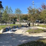 Jacqueline Clements Park picnic area with plantings, ornamental trash barrels, and and pathway lighting