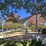 Jacqueline Clements Park fitness area shade sail with and fall color on the trees
