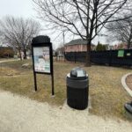 Jacqueline Clements Park community bulletin board with bioretention area in the background