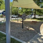Jacqueline Clements Park fitness area features leg lift/pull up station, twist and flex wheel, and steps