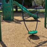 John O'Brien Park playground spinner for ages 5-12 and rock wall to curved slide