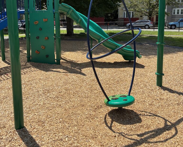 John O'Brien Park playground spinner for ages 5-12 and rock wall to curved slide