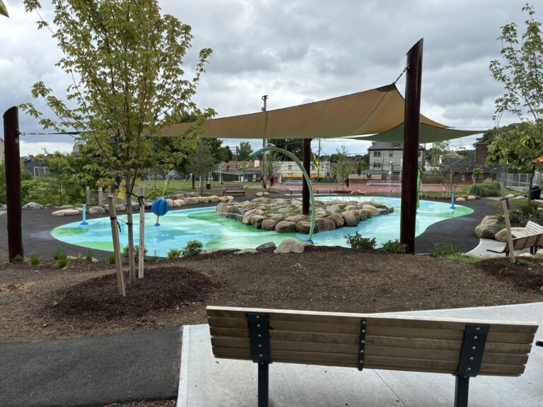 Joslin Park splashpad with multiple seating areas, shade structures, and plantings