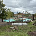 Joslin Park overlooking the splashpad from D'Abate school with a terraced seating area in the foreground