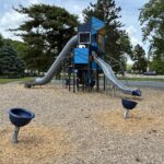 Joe Williams playground equipment includes spinner bowls and two large slides for ages 5-12