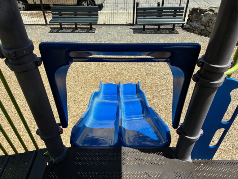 Mattie Smith Park looking down the double slide for ages 5-12 to a pair of park benches