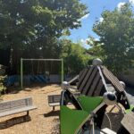 Morris Ave Park features playground bucket swings for ages 2-5, park benches, and a unique climbing structure
